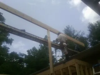 Carpenter setting a ridge beam over a new addition frame — Ice Dam Removal by Roofing Brothers in Bellbrook
