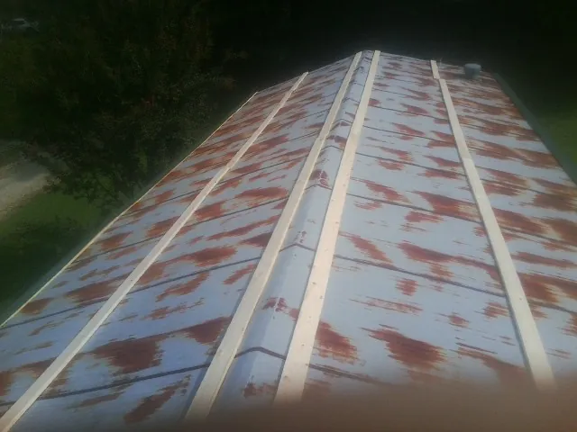Rusted metal roof panels with new wood purlins before replacement — Storm Damage Roof Repair in Bellbrook by Roofing Brothers