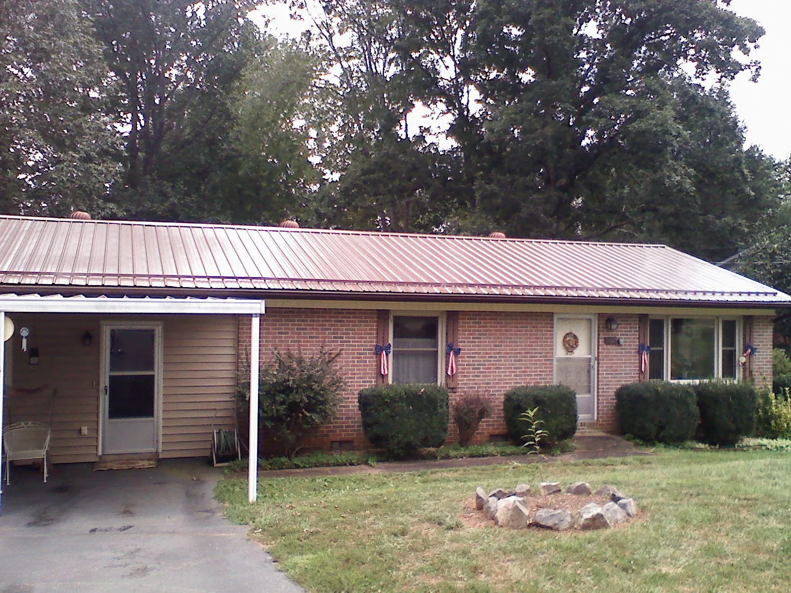 Bronze metal roof and carport on a brick ranch home — Roof Repair work by our crew in Bellbrook